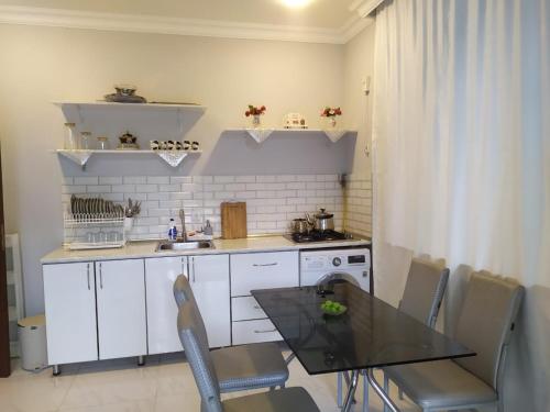 Una cocina con una mesa y sillas y un fregadero. en Cozy Home, en Gabala