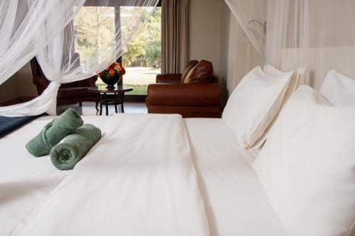 two white beds with stuffed animals on them in a room at Royal Solwezi Hotel in Solwezi