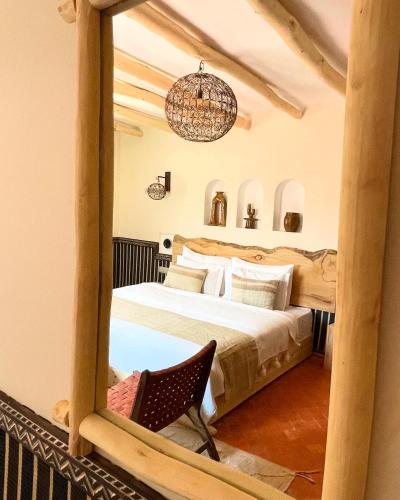 a bedroom with a bed and a mirror at Riad Rihana Dades in Boumalne