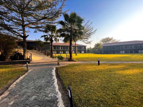 a cobblestone path in front of a building with trees at Royal Solwezi Hotel in Solwezi