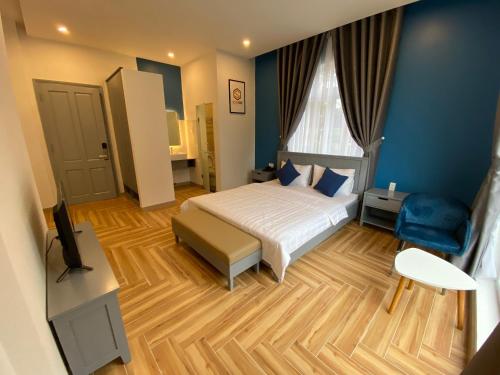 a bedroom with a bed and a blue wall at Sleep Box Anlina Đường 3 Tháng 4 in Xuan An
