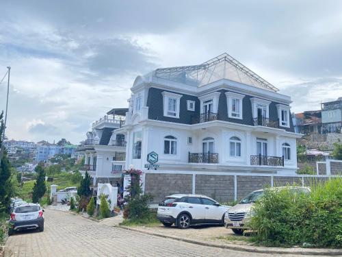 a large house with cars parked in front of it at Sleep Box Anlina Đường 3 Tháng 4 in Xuan An