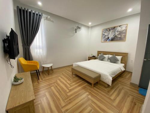 a bedroom with a bed and a desk and a tv at Sleep Box Anlina Đường 3 Tháng 4 in Xuan An