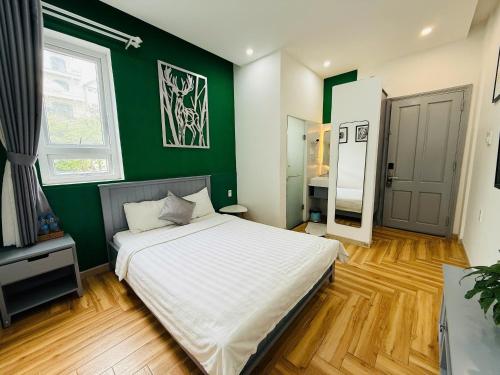 a bedroom with a large bed with a green wall at Sleep Box Anlina Đường 3 Tháng 4 in Xuan An