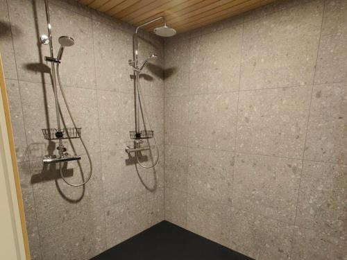 een douchecabine met twee douchekoppen in een badkamer bij Villa Kinoskulma in Kuusamo