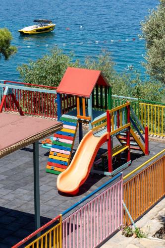 a playground with a slide next to the water at Blue Dreams Resort Bodrum - Aquapark & Ultra All Inclusive in Torba