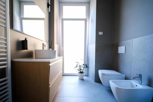 a bathroom with a sink and a toilet and a window at Premier Stay The Tower - Bernina Experience in Tirano
