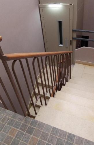 a stairway with a wooden railing and a door at Apartamentos "Casa Melé" 3 in Lleida