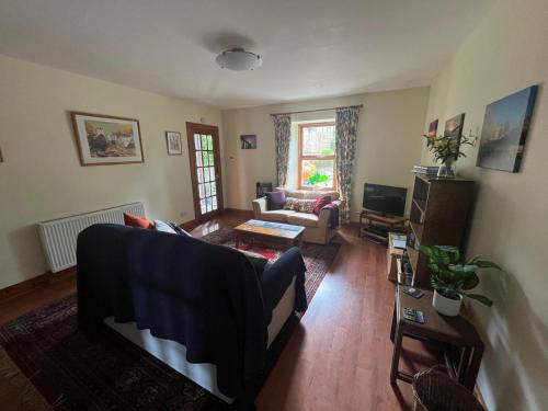 a living room with a couch and a table at Midkinleith Farm Holiday Cottage in Edinburgh