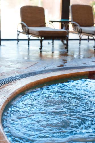 a pool of water with two chairs and a table at Sheraton Pilar Hotel & Convention Center in Pilar