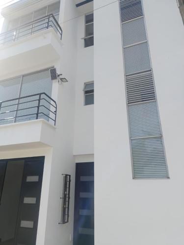 Un edificio blanco con una puerta y un balcón. en Apartamento lindo con Jacuzzi, en Villeta