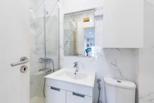 a white bathroom with a sink and a toilet at Benfica City Flat Stay By Perfect Getaway in Damaia