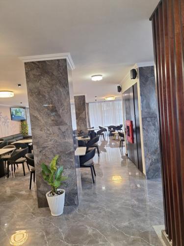a restaurant with a lobby with tables and chairs at Point Central Hotel in Addis Ababa