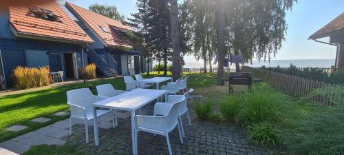 a group of tables and chairs on a lawn at Ant marių kranto-By the Lagoon Apartments in Preila