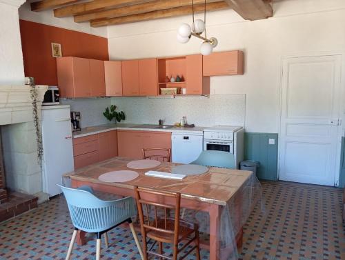 a kitchen with a wooden table and chairs in it at Gîte 3 chambres dans Longère aux Rosiers-sur-Loire in Le Thoureil