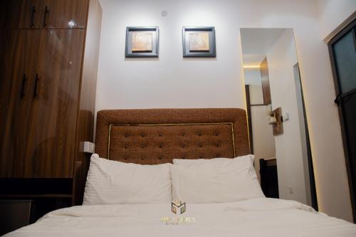 a bedroom with a bed with two pictures on the wall at Minimalist Akoka Studio Near Unilag in Lagos