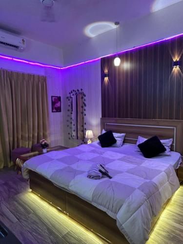 a bedroom with a large bed with purple lighting at MyHaven in Greater Noida
