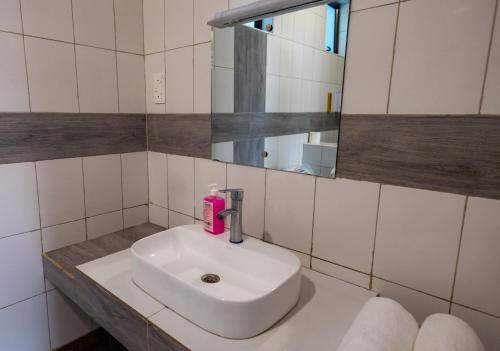 a bathroom with a white sink and a mirror at The Safiya Hotel, Diani Beach in Diani Beach