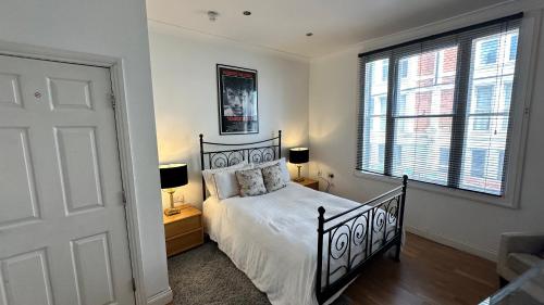 a bedroom with a bed and two lamps and a window at Luxury Room - St Leonards on Sea - East Sussex in Hollington