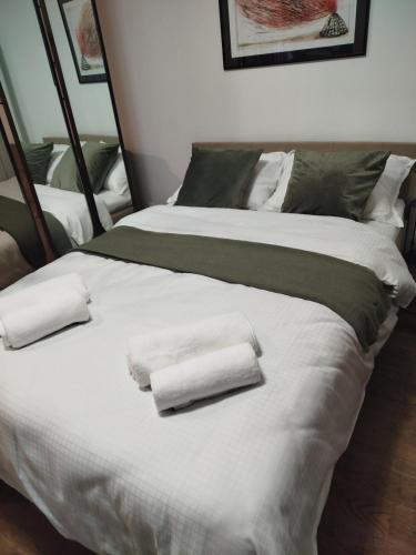 a large bed with two folded towels on it at Urban Elegance Studio & SPA in Niš