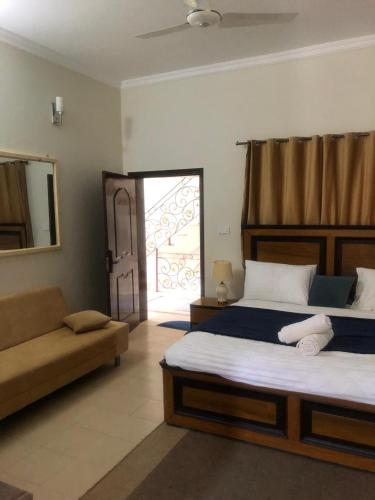 Un dormitorio con una cama y un sofá y una ventana. en Mountain View Resort, en Islamabad