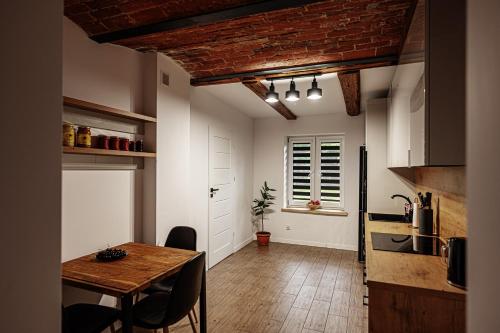 a kitchen with a wooden table and a dining room at Siedlisko Wilczyny 