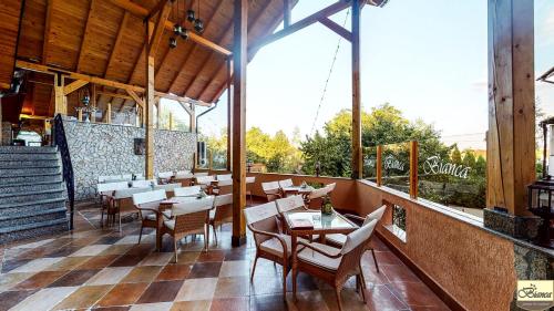 a restaurant with tables and chairs and a large window at Pensiunea Bianca in Botoşani