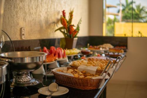 Un buffet con muchos platos de comida en una mesa. en Andimar Hotel, en Porto Seguro