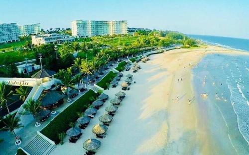 an aerial view of a beach with umbrellas and cars at Apartment Beachfront Phan Thiet-Ocean Vista-C315 in Ấp Ngọc Hải