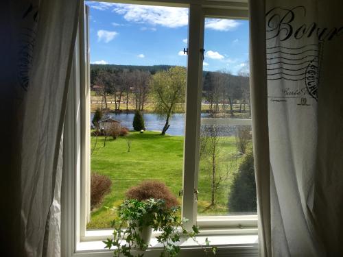 a window with a view of a green field at Bergsmansgårdens Gästhus in Asphyttan