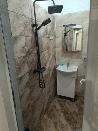 ein Badezimmer mit Dusche und Waschbecken in der Unterkunft Апартамент за гости Централ in Malko Tŭrnovo