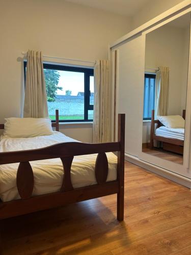 a bedroom with a bed and a large window at IEC Campus for Groups in Kanturk