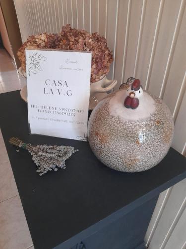 a book and a vase on a table with a sign at Casa La V G in Almese