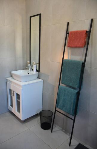 a bathroom with a sink and a mirror at Dullight Self Cater Cottage in Dullstroom