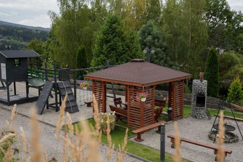 a playground with a wooden gazebo and a swing at Domek drewniany w górach Jacuzzi & Balia - Osada Chełm in Stróża