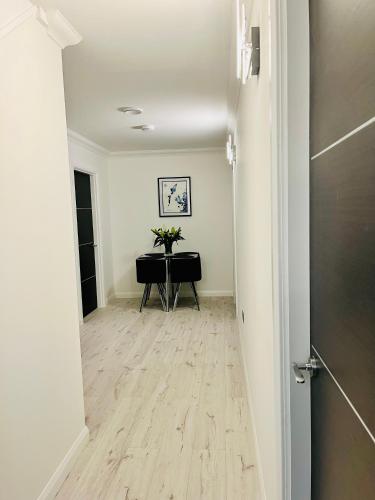 a hallway with a table and flowers in a room at Lewis Living in Aird Tong