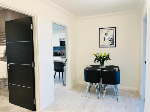 a dining room with a black table and chairs at Lewis Living in Aird Tong