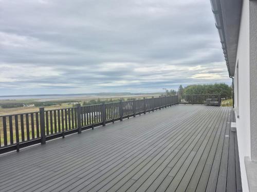 a balcony with a wooden floor and a fence at Lewis Living in Aird Tong