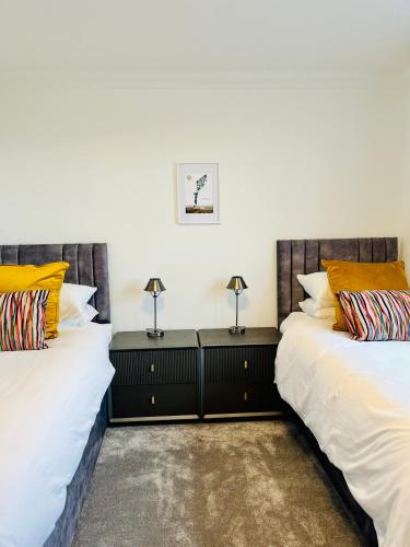 two beds sitting next to each other in a room at Lewis Living in Aird Tong