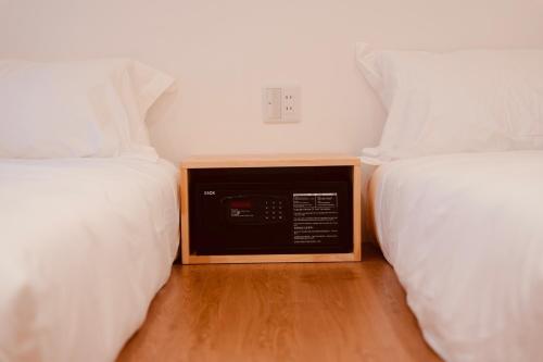 a room with two beds with a radio between them at 雪山民宿 YUKI YAMA Hotel in Osaka