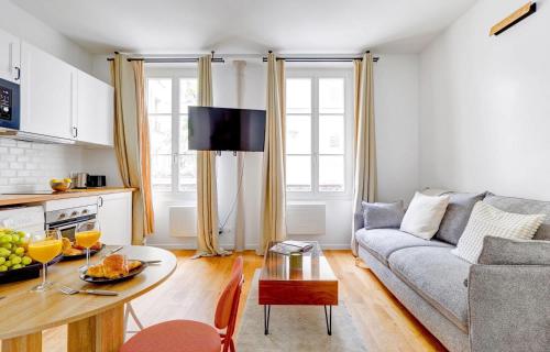 a living room with a couch and a table at BnBNova - 1BR - Eiffel Tower & Rue Gros Caillou in Paris