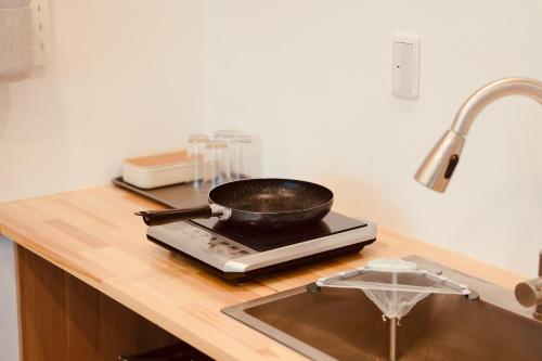a frying pan on top of a stove in a kitchen at 雪山民宿 YUKI YAMA Hotel in Osaka