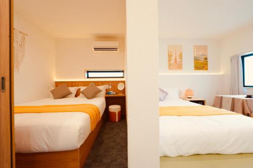 a bedroom with two beds and a table at 雪山民宿 YUKI YAMA Hotel in Osaka