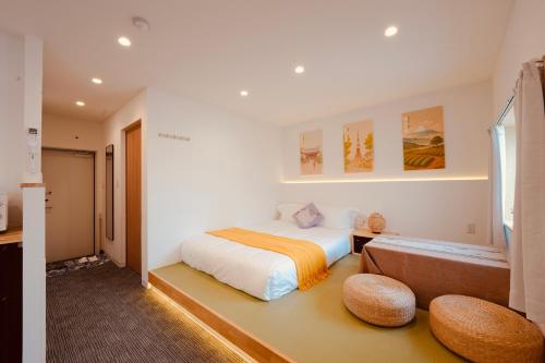 a bedroom with a bed and two ottomans at 雪山民宿 YUKI YAMA Hotel in Osaka