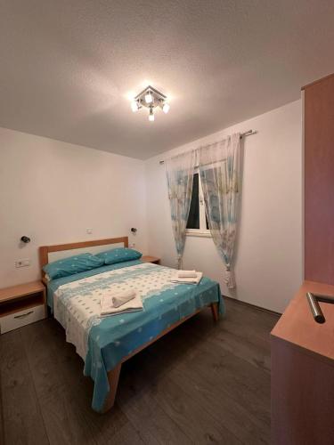 a bedroom with a bed and a window at Apartman 3 Majba in Zaglavice