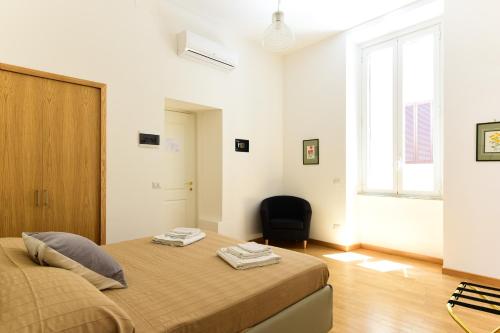 ローマにあるCS Cosy Termini Studioのベッドルーム1室(ベッド1台、黒い椅子付)