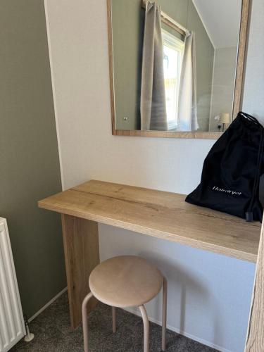 a wooden counter with a stool and a mirror at Its Time to Breathe in Whitley Bay