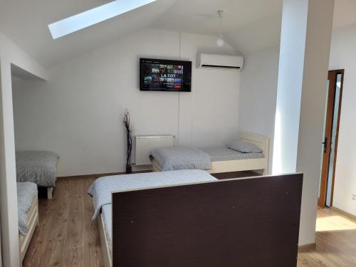 a room with two beds and a tv on the wall at Vila Vati - Arena Pitesti in Piteşti