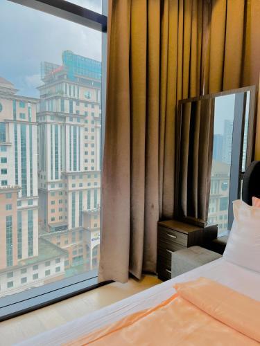 a bedroom with a window with a view of a city at Premier Suites Twin Towers at Star Residences in Kuala Lumpur