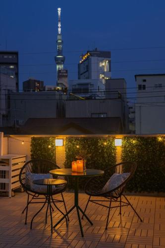 a table and chairs on a balcony with a view of a city at Skytree View Rooftop Villa Asakusa SVRVA in Tokyo